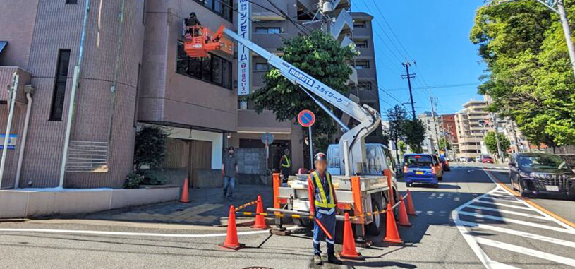高所作業車を使用して看板の設置工事を行っている様子